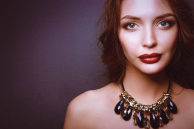 Siyah elbiseli, akşam makyajlı güzel bir kadın.