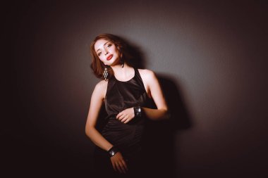 Siyah elbiseli, akşam makyajlı güzel bir kadın.