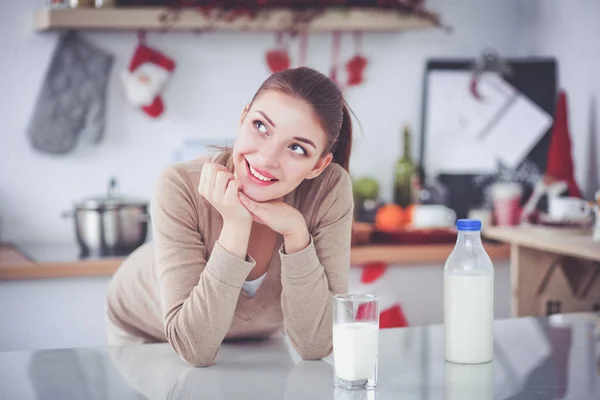 Jovem smilling mulher de pé em sua cozinha — Fotografia de Stock