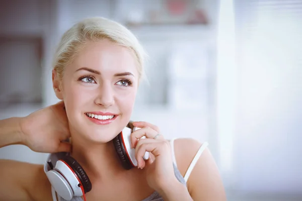 Joven hermosa mujer en casa sentada en el sofá y escuchando música —  Fotos de Stock