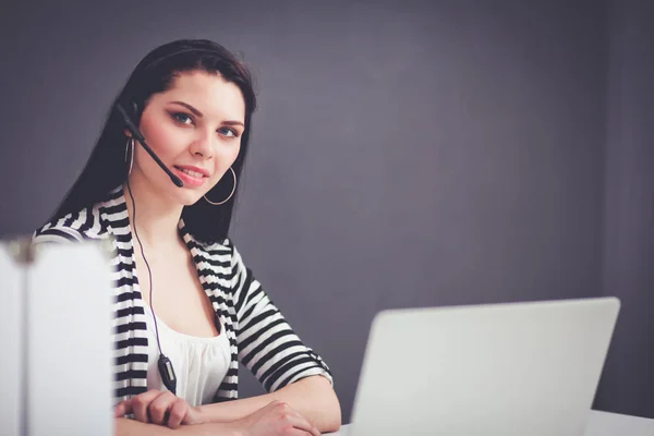 Hermosa mujer de negocios que trabaja en su escritorio con auriculares y portátil — Foto de Stock