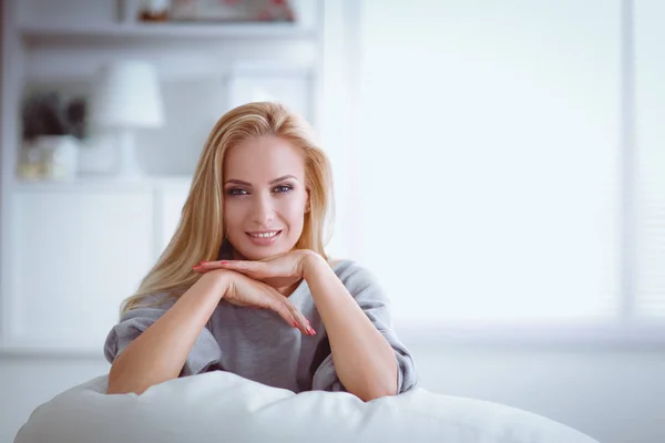 Young beautiful woman sitting on couch at her room — Stock Photo, Image