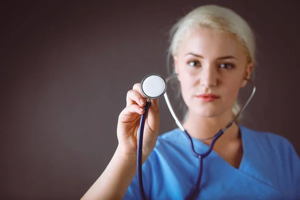 Médica feminina com estetoscópio ouvindo, isolada em fundo cinza — Fotografia de Stock