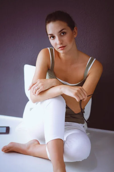 Attractive caucasian girl sitting on floor with cup and tablet near wall — Stock Photo, Image