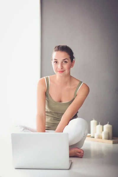 Aantrekkelijke Kaukasische meisje, zittend op de vloer met laptop — Stockfoto