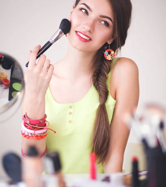 若くてきれいな女性を手に保持して化粧用ブラシ — ストック写真
