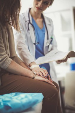 Doktor ve hasta masada otururken bir şey tartışıyorlar. Tıp ve sağlık hizmetleri kavramı. Doktor ve hasta.