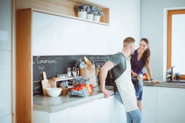 Güzel genç çift evde mutfakta eğleniyor.