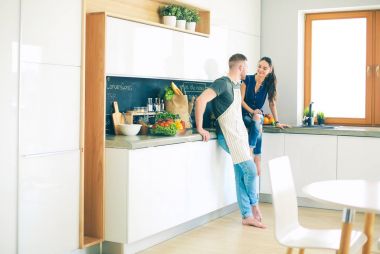 Güzel genç çift evde mutfakta eğleniyor.