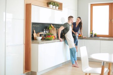 Güzel genç çift evde mutfakta eğleniyor.