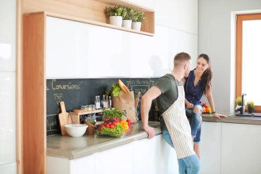 Güzel genç çift evde mutfakta eğleniyor.