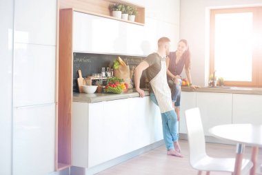 Güzel genç çift evde mutfakta eğleniyor.