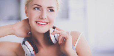 Evdeki genç ve güzel kadın kanepede oturup müzik dinliyor.