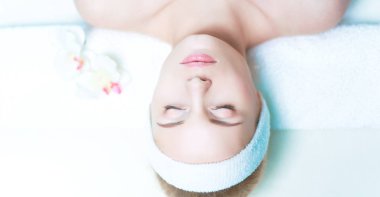 Güzel genç bir kadın masaj yaptırıyor, kuaförde yatıyor.