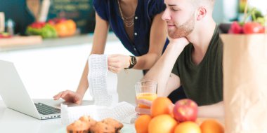 Çift evde mutfak içinde laptop ile onların fatura ödeme
