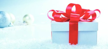 Kırmızı kurdeleli beyaz hediye kutusu.