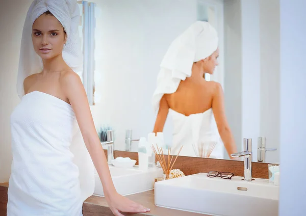 Jeune femme attrayante debout devant le miroir de salle de bain — Photo