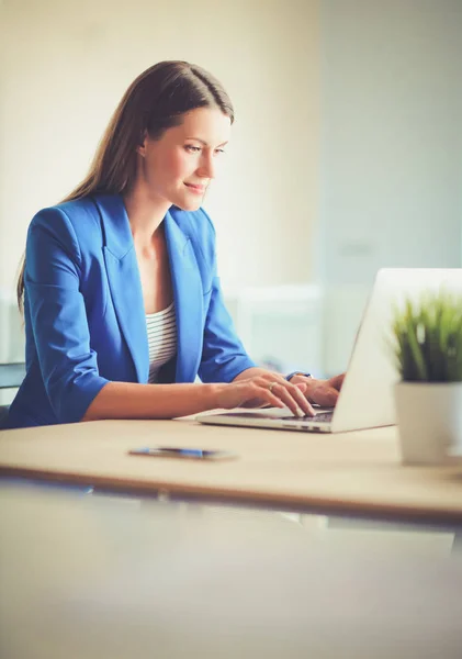 Kobieta siedząca na biurku z laptopem — Zdjęcie stockowe