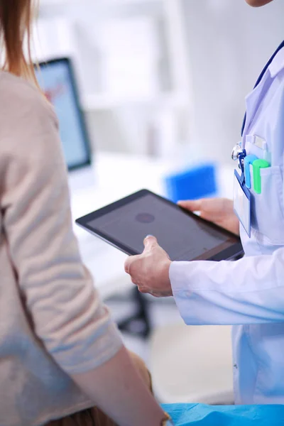 Dokter en patiënt bespreken iets terwijl ze aan tafel zitten. Geneeskunde en gezondheidszorg. Dokter en patiënt — Stockfoto