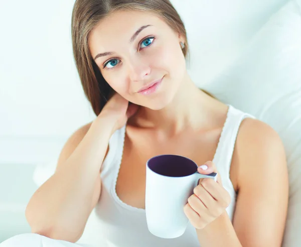 Mulher bonita na cama desfrutando de uma xícara de chá — Fotografia de Stock