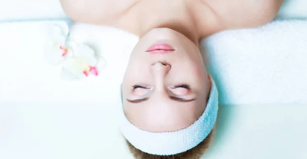 Hermosa joven recibiendo masaje de spa, tumbado en el salón —  Fotos de Stock