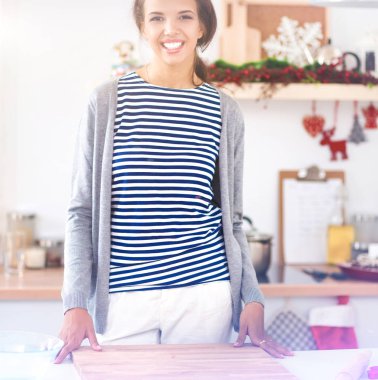 Masasının yanında duran genç bir kadın.