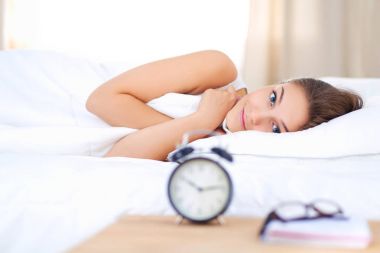 Genç bir kadın sabah alarmını erteliyor..