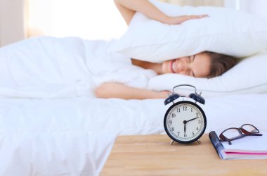 Genç bir kadın sabah alarmını erteliyor..