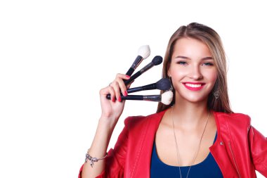 Genç güzel kadın elinde makyaj için fırça tutar .