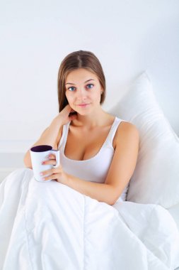 Genç ve güzel bir kadın yatakta oturuyordu .