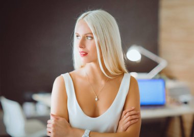 Moda tasarımcıları stüdyoda çalışıyor. Masanın üzerinde oturuyorlar..