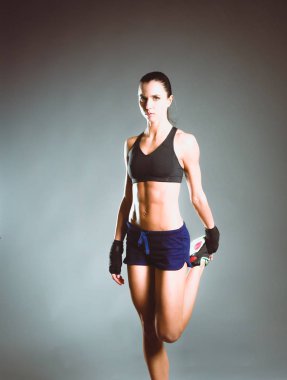 Spor giyim siyah arka plan karşı poz kas genç kadın.