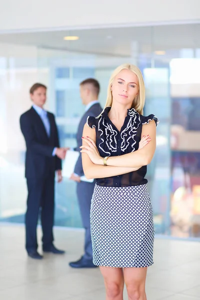 Zakenvrouw permanent op voorgrond in office . — Stockfoto