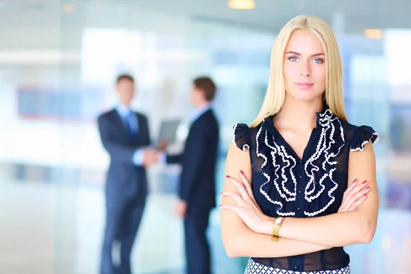 Portret van jonge zakenvrouw in functie met collega 's op de achtergrond . — Stockfoto