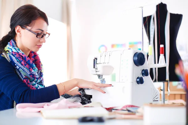 Genç terzi kâğıt üzerinde kıyafet deseni tasarlıyor. .