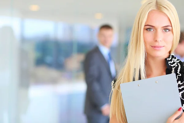 Portrait of young businesswoman in office with colleagues in the background . — Stock Photo, Image