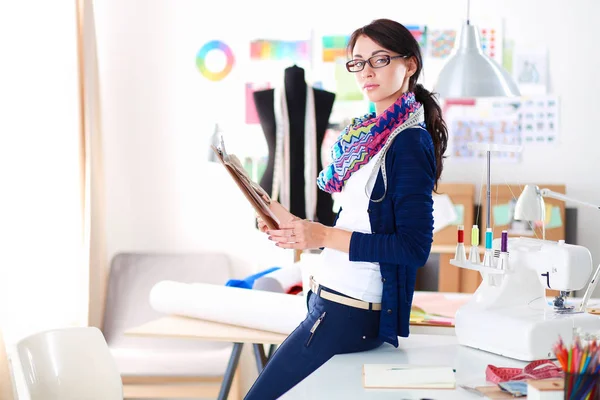 Schöne Modedesignerin steht im Atelier . — Stockfoto