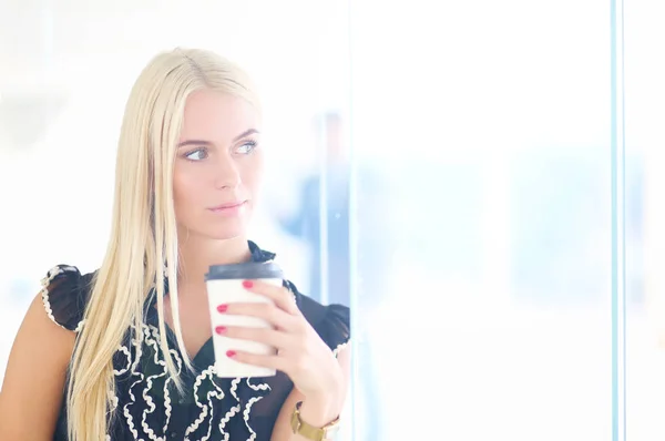 Geschäftsfrau mit einer Tasse Kaffee im Büro . — Stockfoto