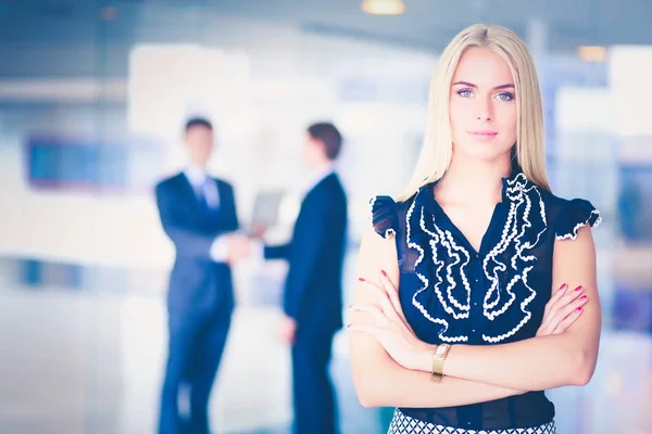 Portret van jonge zakenvrouw in functie met collega 's op de achtergrond . — Stockfoto