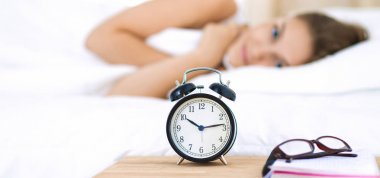 Genç bir kadın sabah alarmını erteliyor.