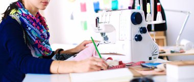 Çalışırken dikiş diken genç bir kadın.