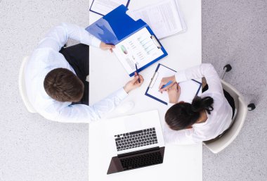 İş adamları iş toplantısında, ofiste oturup tartışıyorlar.