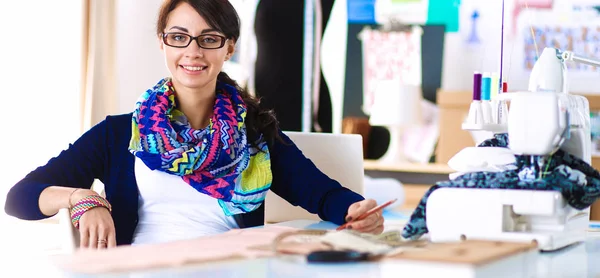 Mooie modeontwerper zit aan het bureau in studio — Stockfoto