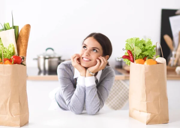 Portrait of a smiling woman cooking in her kitchen sitting — Stock Photo, Image