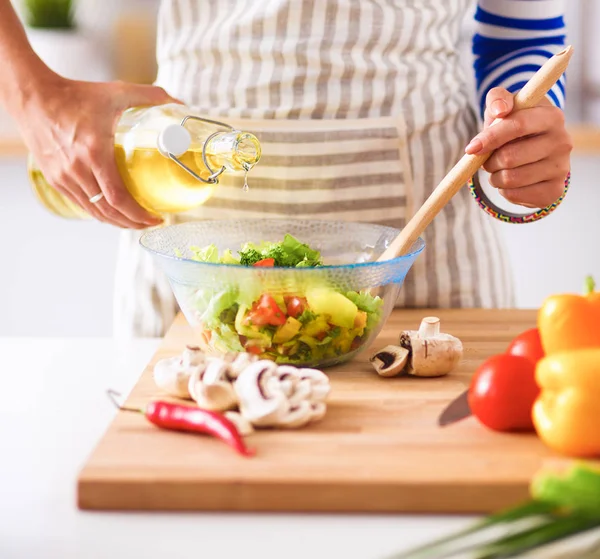 Junge Frau mixt frischen Salat — Stockfoto