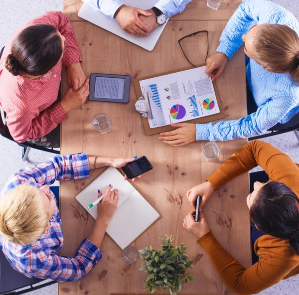 İş adamları iş toplantısında, ofiste oturup tartışıyorlar.