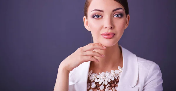 Porträt einer jungen Frau mit Perlen, stehend auf grauem Hintergrund — Stockfoto