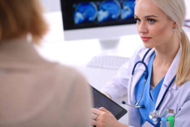 Doktor ve hasta masada otururken bir şey tartışıyorlar. Tıp ve sağlık hizmetleri kavramı. Doktor ve hasta.