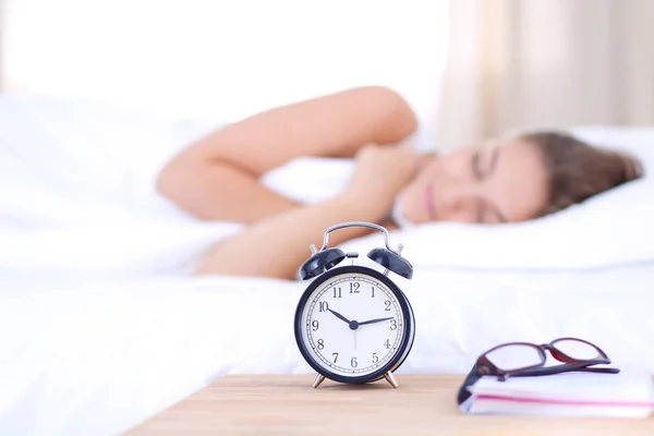 A young woman putting her alarm clock off in the morning. — Stock Photo, Image