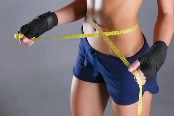 Fitness womans vacker kropp med måttband — Stockfoto